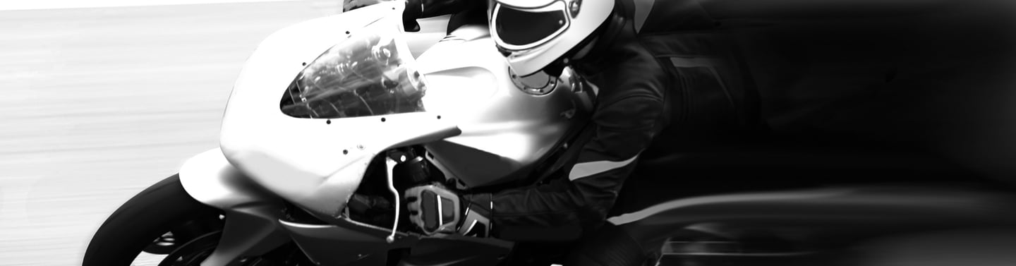 closeup of a motorcycle front end and rider as it is clearly taking a corner