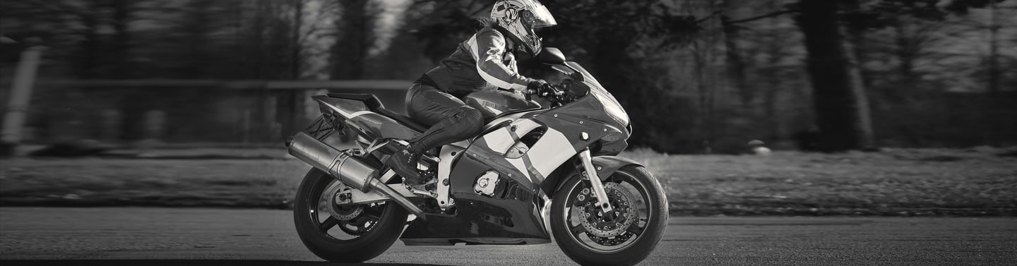 Side view of motorcycle as it ride past from left to right
