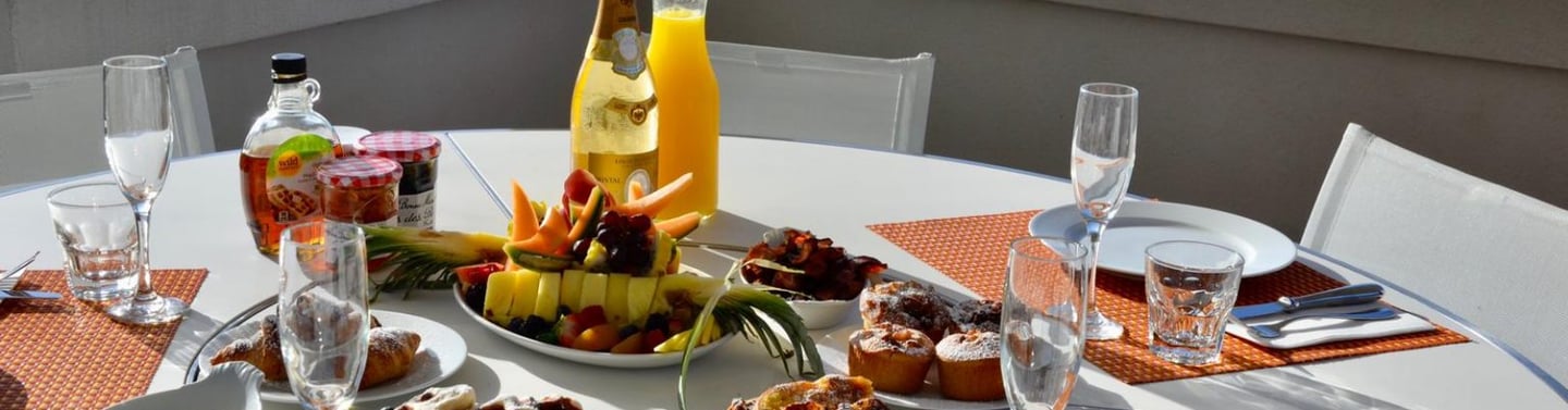 Petit déjeuné dressé sur une terrasse de villa aux Terres Basses