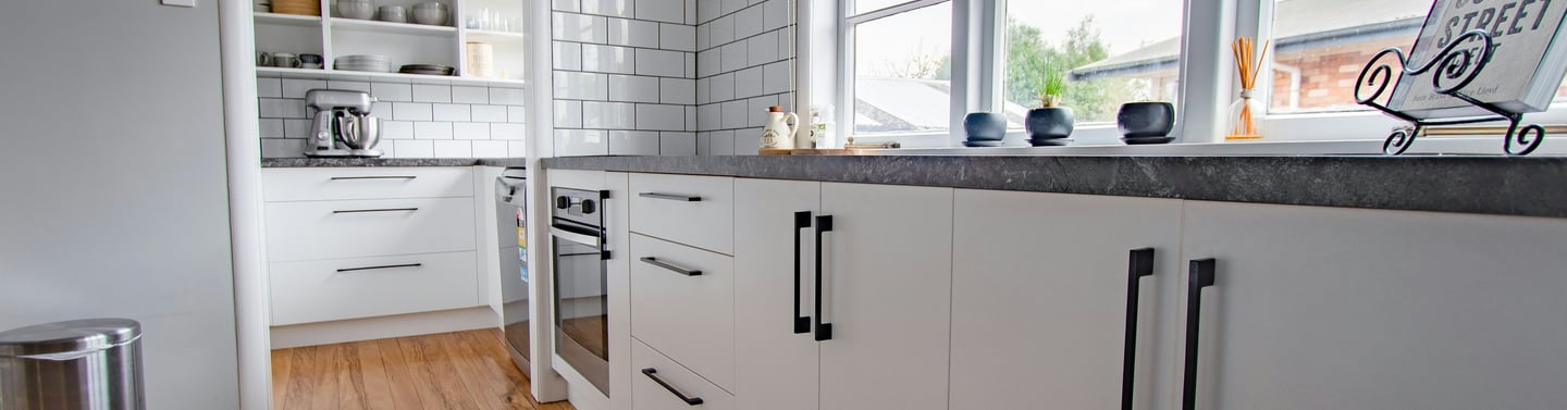 eco friendly flooring options for a kitchen with a wooden floor and white cabinets