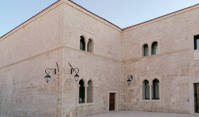a building with a clock on the outside, how to get to Pag from Italy