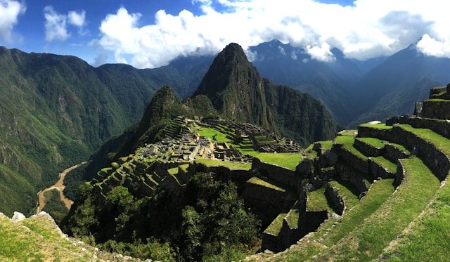 Scenic view of Machu Picchu ruins surrounded by lush green mountains in Peru.
