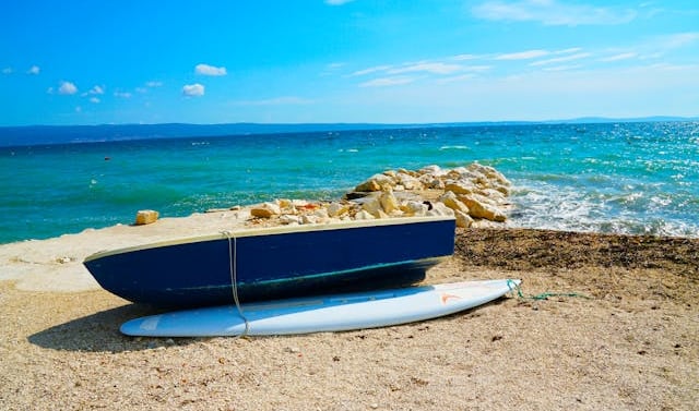 a surfboarder sitting on the beach, best tourist cities in Croatia