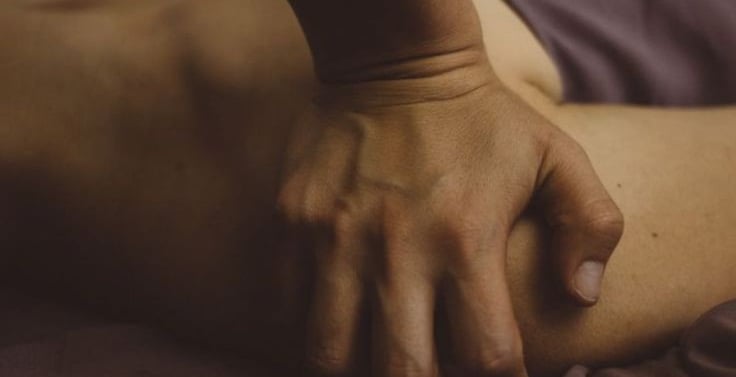 masajista ejerce presión palmar sobre hombro derecho