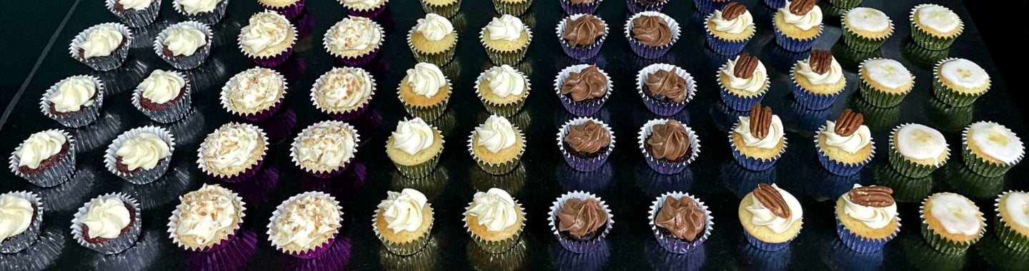 a bunch of cupcakes with white frosting and chocolate frosting