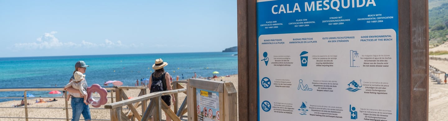 Cala Mesquida beach sign post with the sea in the background