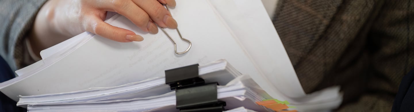 una mujer sosteniendo una carpeta con documentos clínicos