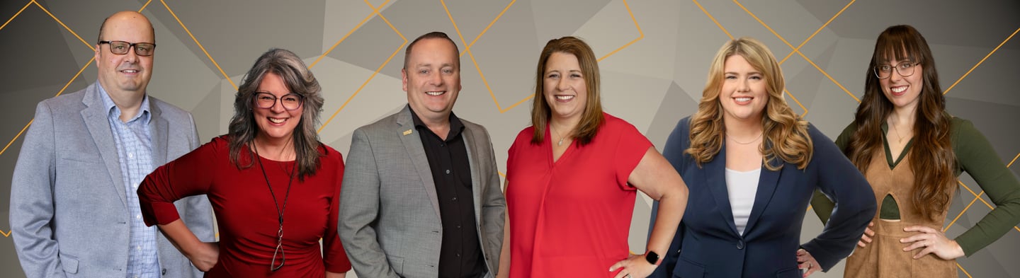 Professional business team portrait featuring diverse corporate staff smiling against a geometric background.