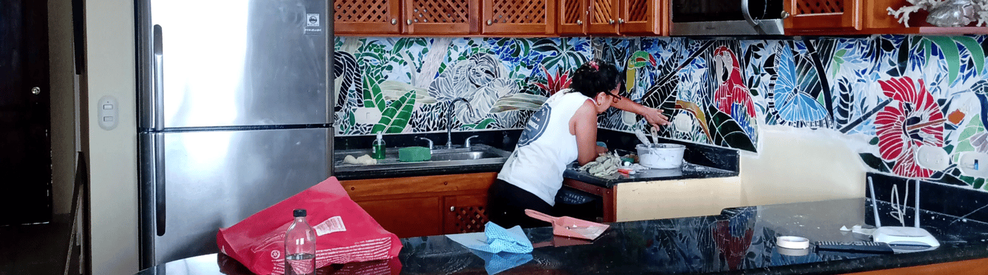 a woman designing and cleaning a mosaic  kitchen counter top