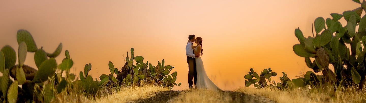 sposi che si baciano al tramonto in un paesaggio di Ragusa