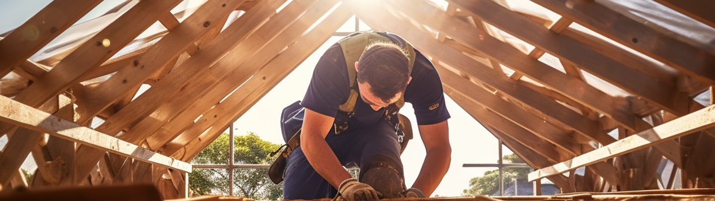 Worker installing roof trusses, illustrating bookkeeping services tailored to construction business.