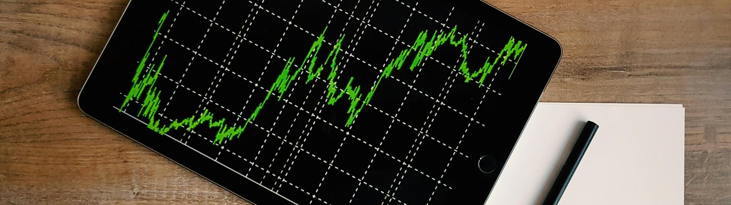 Um tablet mostrando um grafico com uma tendencia de crescimento.