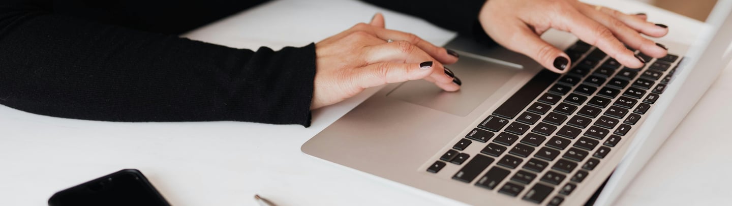 a woman sitting at a desk with a laptop and a cell phone, career change cover letter