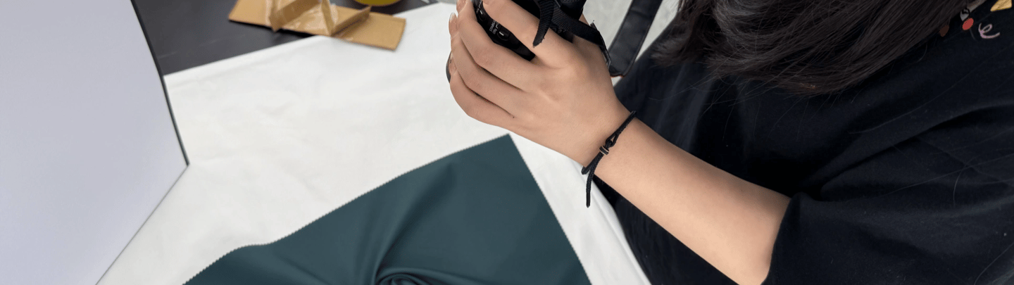 Photographer shooting YL fabric in deep blue velvet on a white table with a DSLR camera.