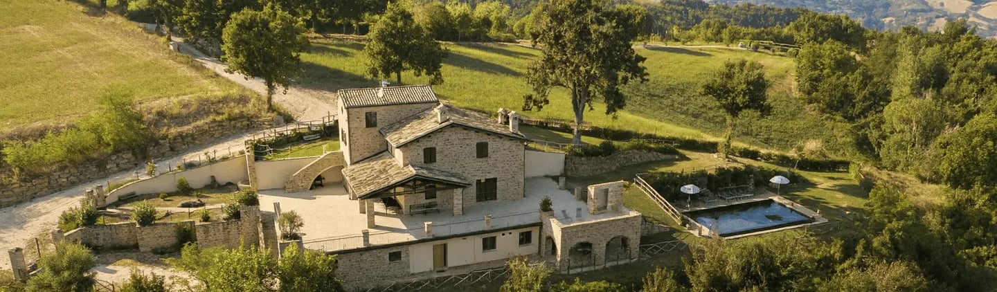 vista villa in pietra tra colline Marche