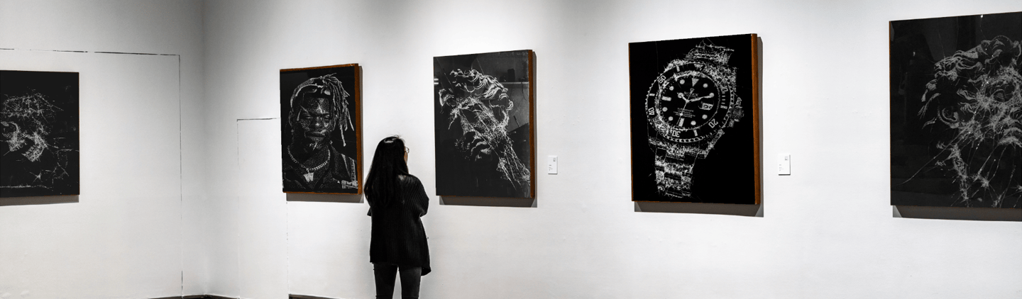 a person standing in front of a wall with paintings