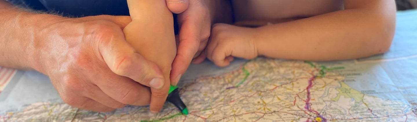 Parent et enfant faisant un tracé sur la carte sur la côte normande