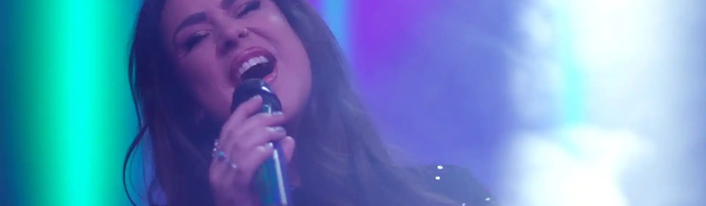 a woman in a black dress singing into a microphone