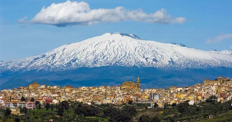 Panoramic view of the hiSicily with the snow-capped Mount Etna volcano in the background.