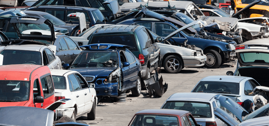 A bunch of cars parked in a scrap yard