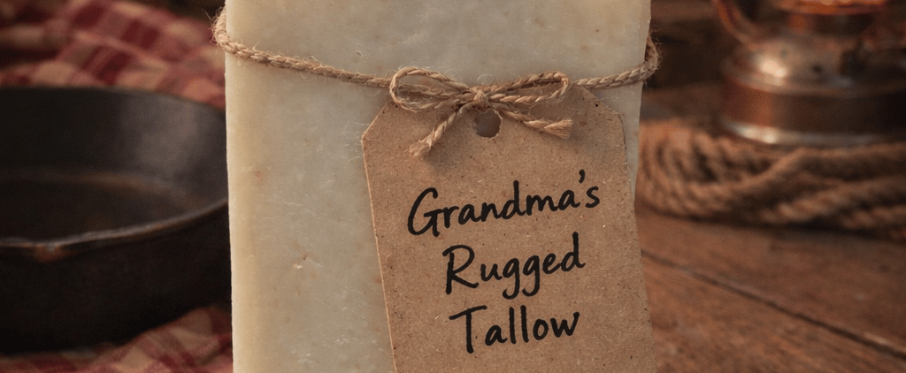 Handmade organic tallow soap bar with a rustic twine label on a wooden table by a cozy fireplace.