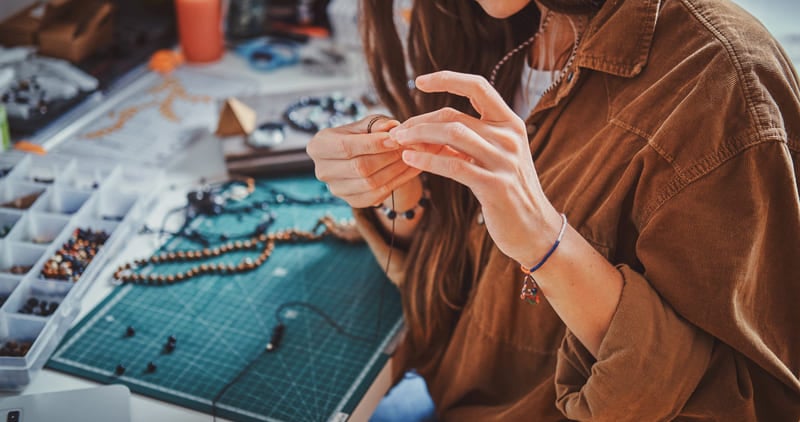 Mujer artesana haciendo joyería.
