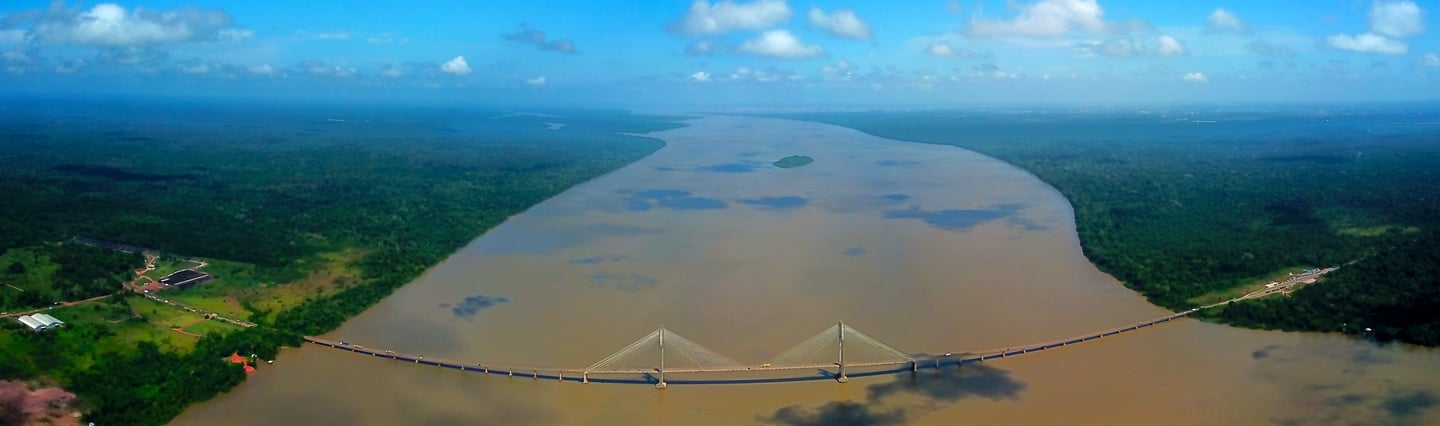 a bridge spanning a river with a bridge in the background