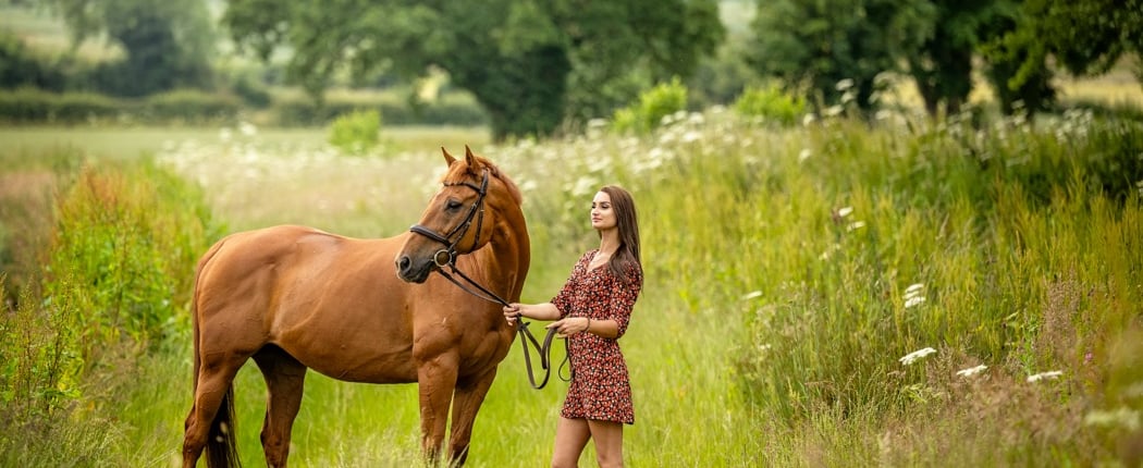 equine photograph of woman in a dress standing in a field