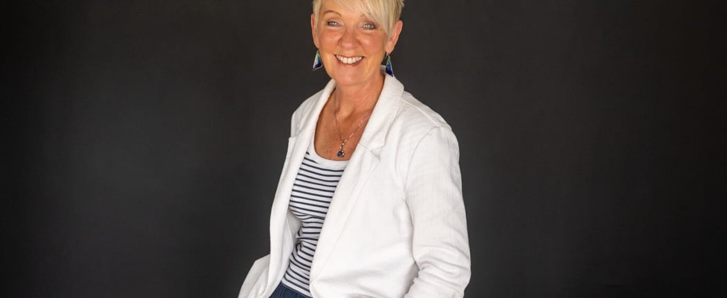 a business headshot woman in a white jacket and blue pants