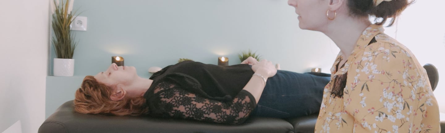Une hypnothérapeute induit une transe hypnotique à une femme allongée sur une table de massage