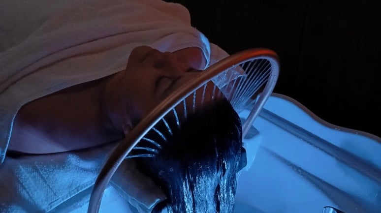 Client recois un soin capillar headspa au salon Insia 