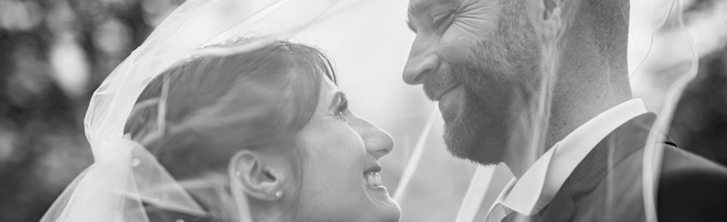 a bride and groom standing in front of a tree