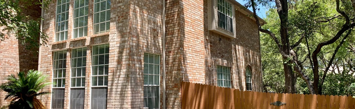 Professional window cleaner efficiently working on a residential home, showcasing time-effective