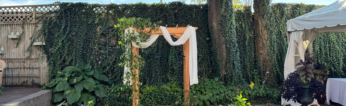a wedding ceremony with a wooden arch decorated with flowers