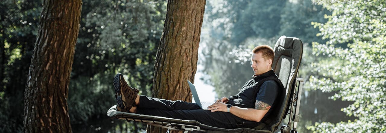 a man sitting on a chair in a park, how to become a digital nomad