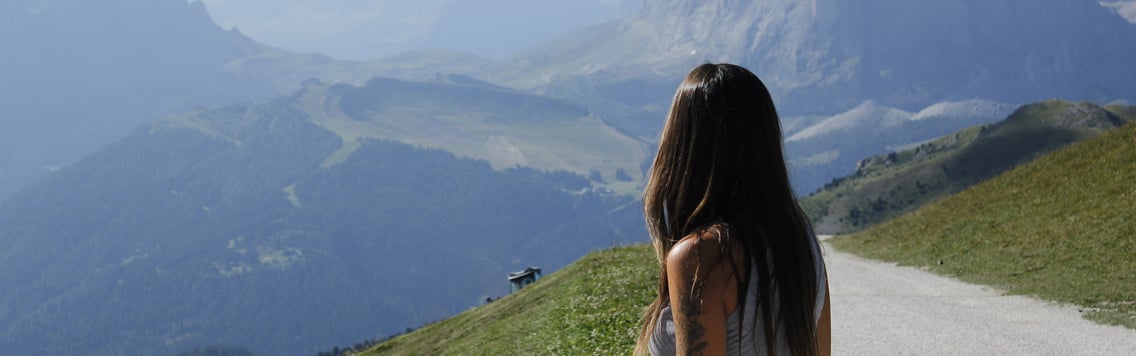 Magui fotografiada de espaldas viendo una montaña soleada