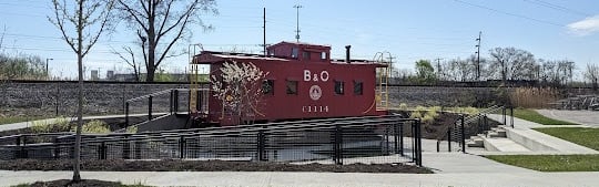 A RED CABOOSE TRAIN CAR SITTING ON A TRACK IN WORTHINGTON OHIO
