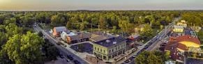 AERIAL VIEW OF DOWNTOWN POWELL OHIO DURING THE DAY SHOWING THE CITIES BUILDINGS AND PARKS
