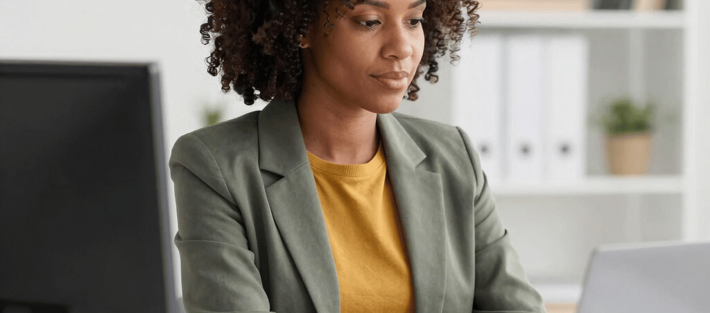 Photo of a friendly bookkeeper at a desk with financial documents and a laptop, focused on organizing records.