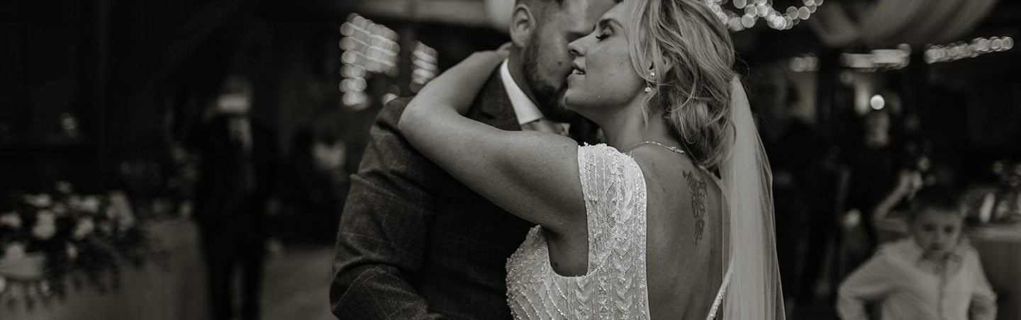 a bride and groom kissing in a barn wedding