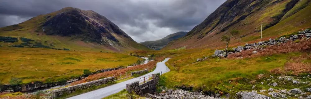 a winding road in the scottish mountains
