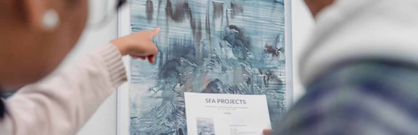 Business team at a gallery reviewing art installation plans.
