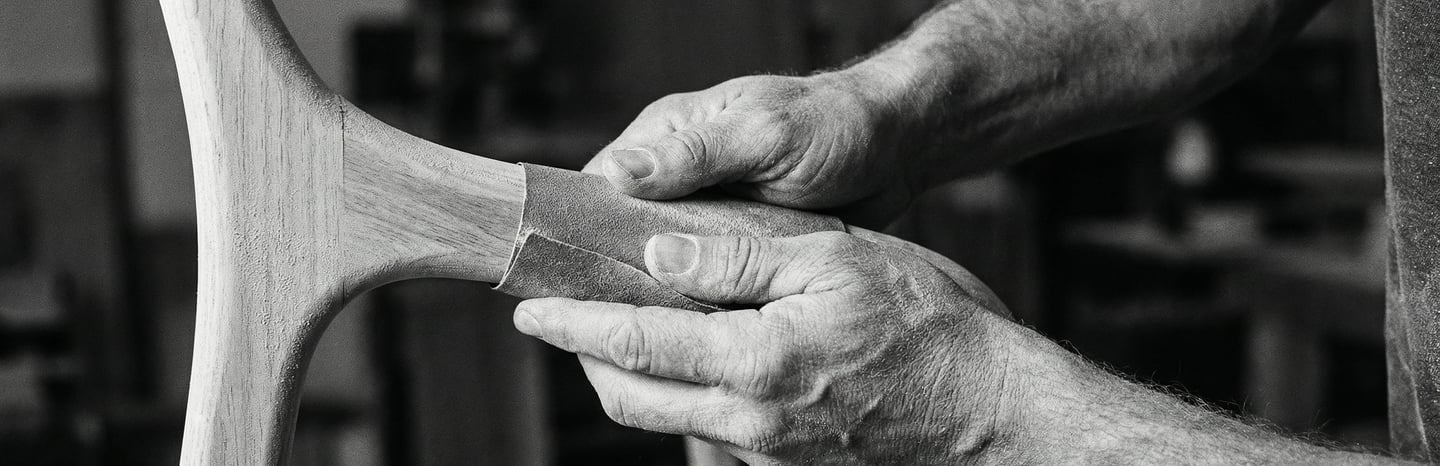Hands of french craftman sanding an organic piece of wood