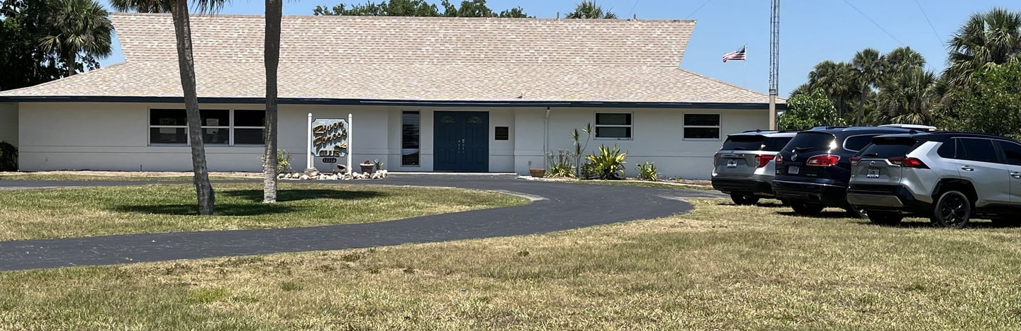 a clubhouse with cars parked in front of a clubhouse