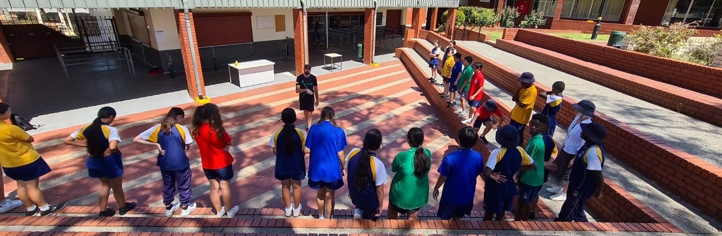 a group of children and adults standing in a line learning life skills