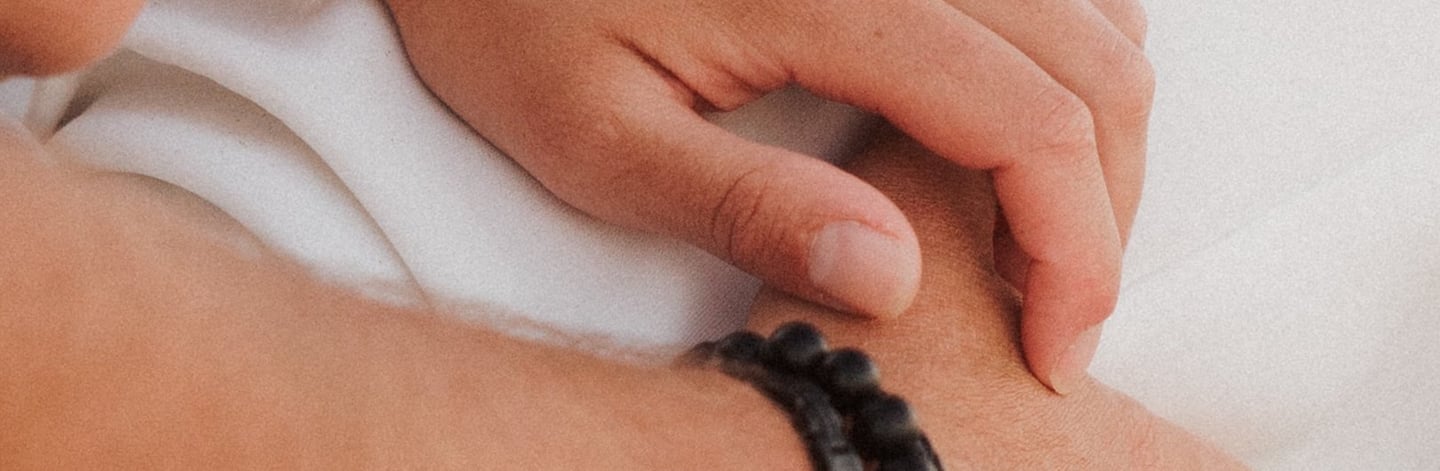 Gros plan sur les mains d'un couple qui se frôlent avec tendresse. Détail organique d'une séance