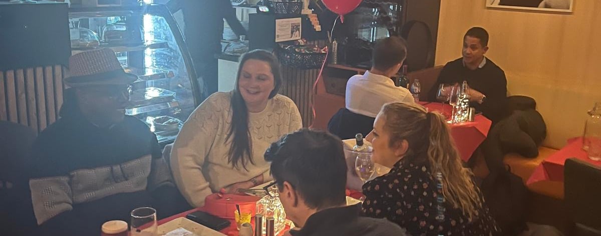 a group of people sitting at a table with balloons