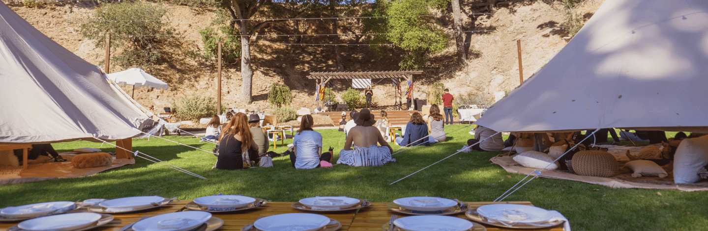 a group of people sitting around a table with plates and plates retreat event planner