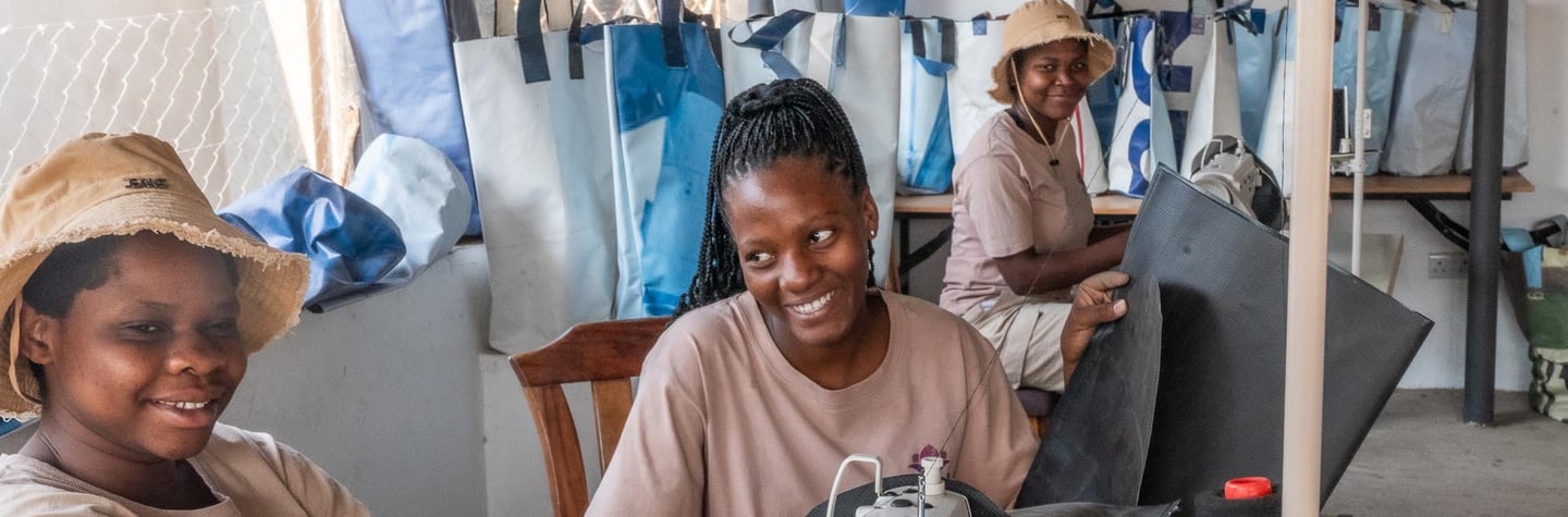 3 ladies smiling at work in the tailor shop