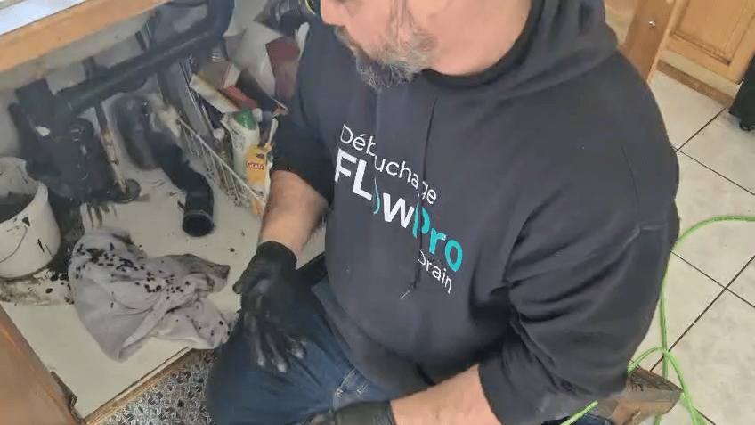 Technicien Flow Pro Drain effectuant un nettoyage professionnel de drain commercial par hydro-jet.